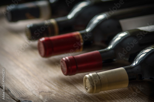 Row of wine bottles on the wooden table. Low depth of field. © aleks-p
