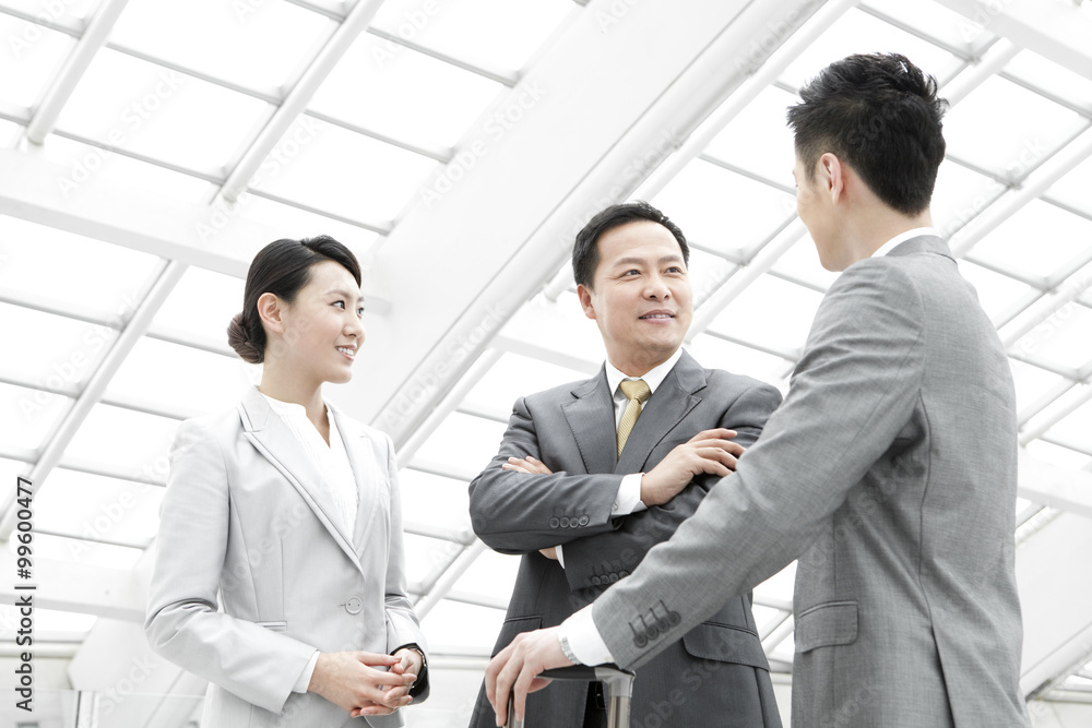 Business partners having conversation in airport lobby Business partners having conversation in airport lobby