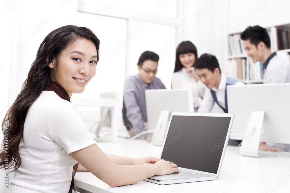 Female office worker using laptop in studio Female office worker using laptop in studio