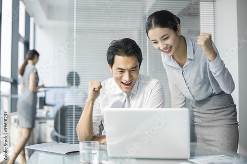 Young businesswoman and businessman talking in office