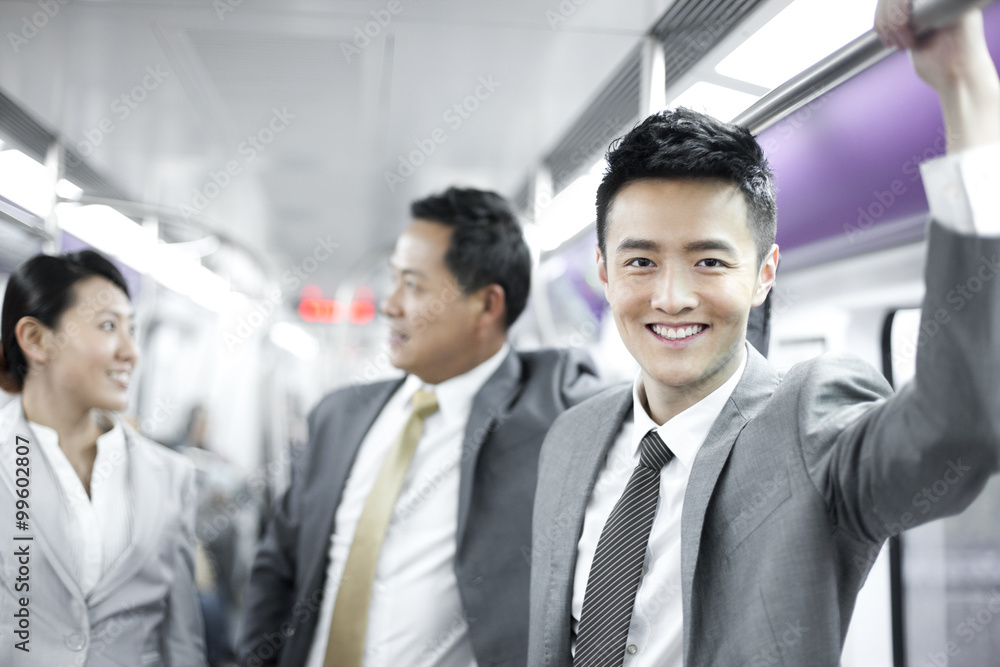 Cheerful businessman with partners in subway train Cheerful businessman with partners in subway train