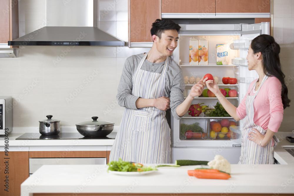 Happy young couple preparing meal