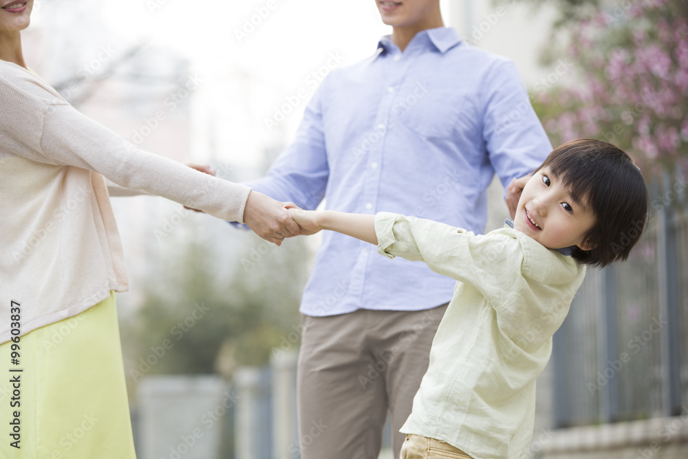 Obraz premium Happy boy holding his parents' hands