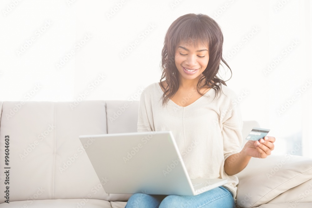 Smiling casual woman buying things with her laptop Smiling casual woman buying things with her laptop