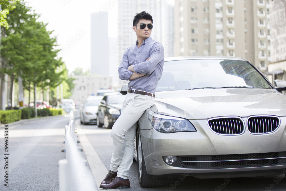 Young man leaning against his car Young man leaning against his car