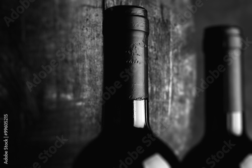 Obraz na plátně red wine bottle - tilt shift selective focus effect black and white photo
