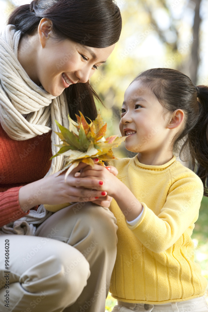 Mother and daughter collecting leaves Mother and daughter collecting leaves