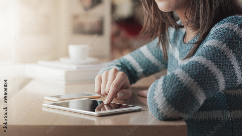 © stokkete - Young woman at the bar using a tablet