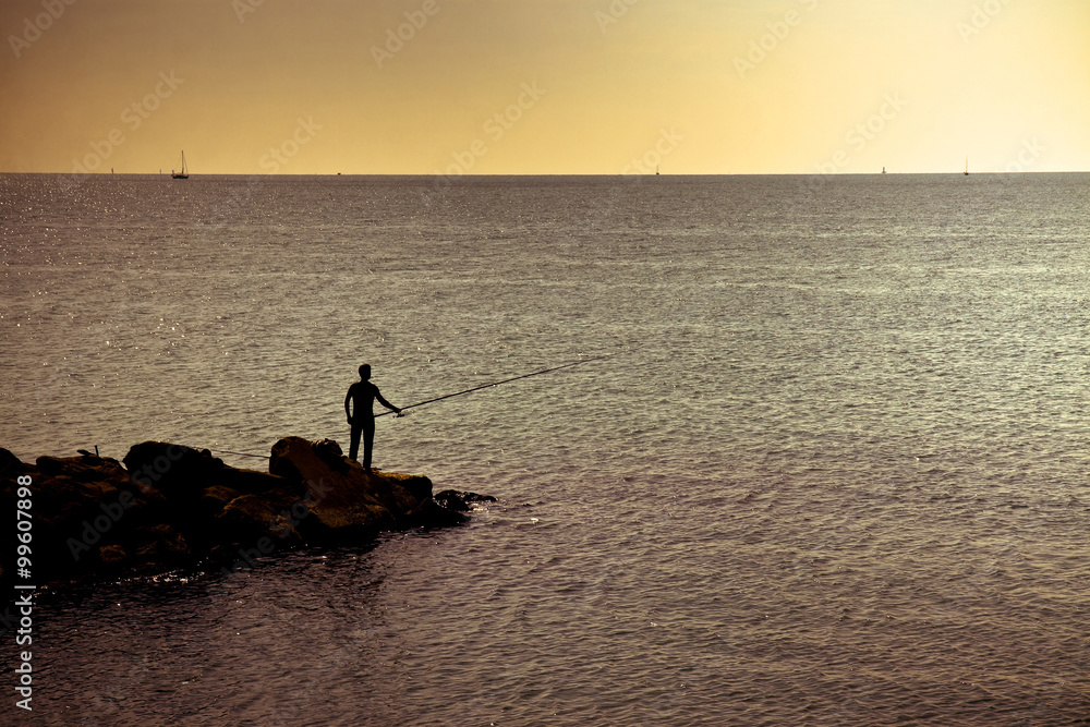 Fototapeta premium Silhouette of a fisherman at sunset in the Mediterranean sea