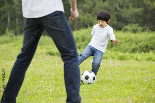 Happy father and son playing football together © Blue Jean Images