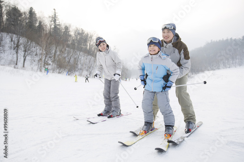 Young parents teaching son to ski