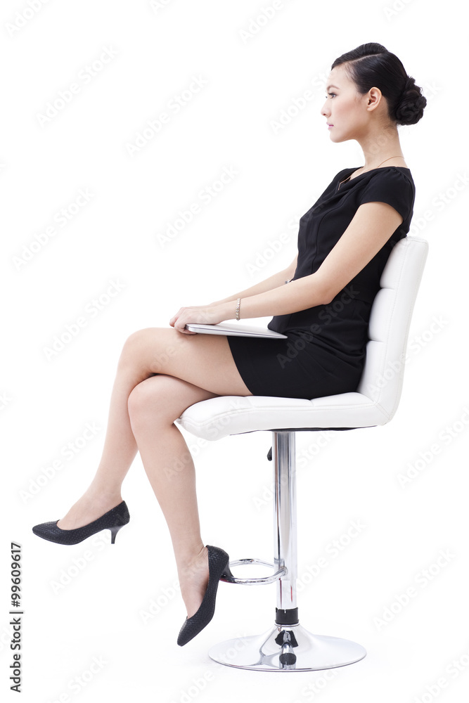 Cool businesswoman sitting on the chair with laptop in hand Cool businesswoman sitting on the chair with laptop in hand