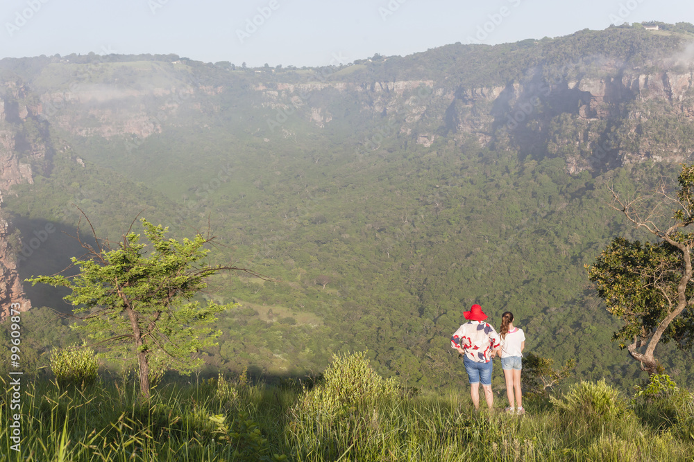 Obraz premium Girl Hiking Wilderness overlooking rural valley landscape summer.