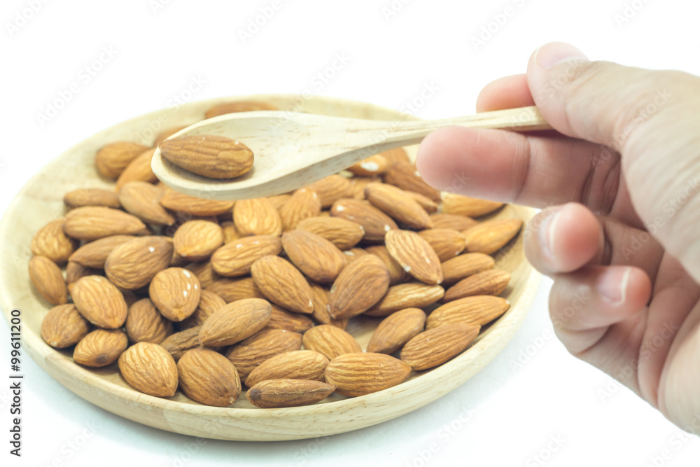 Hand on spoon of almond isolated on white background Hand on spoon of almond isolated on white background