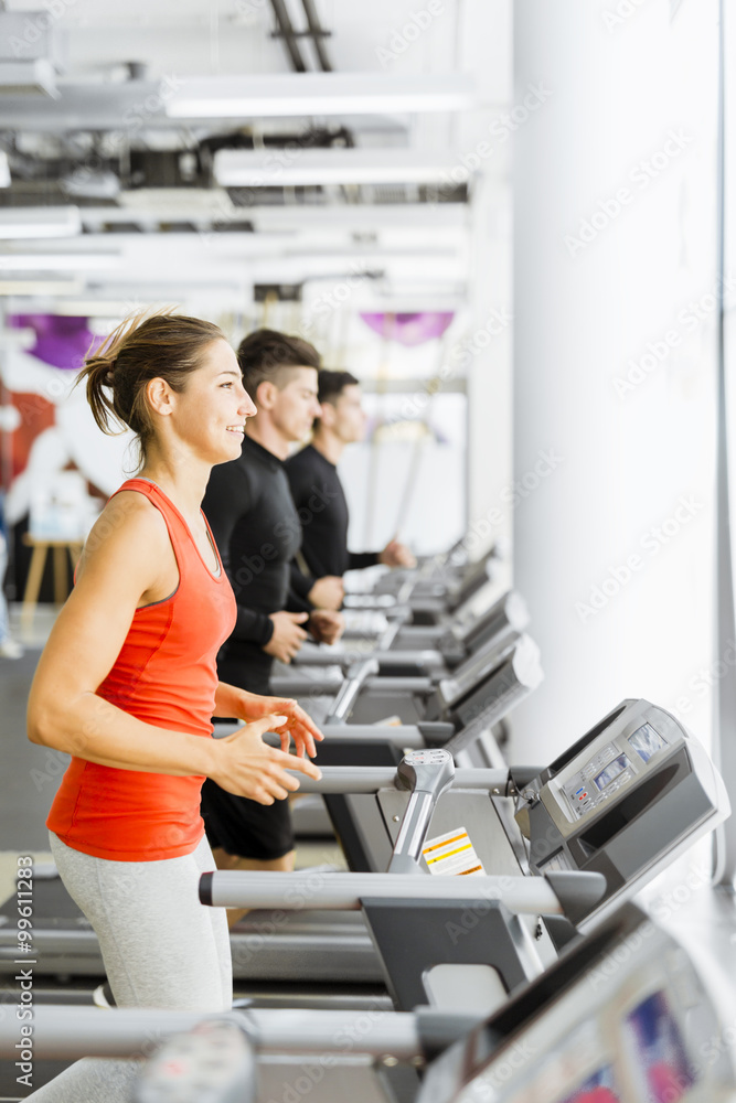 Group of young people using treadmills in a gym Group of young people using treadmills in a gym