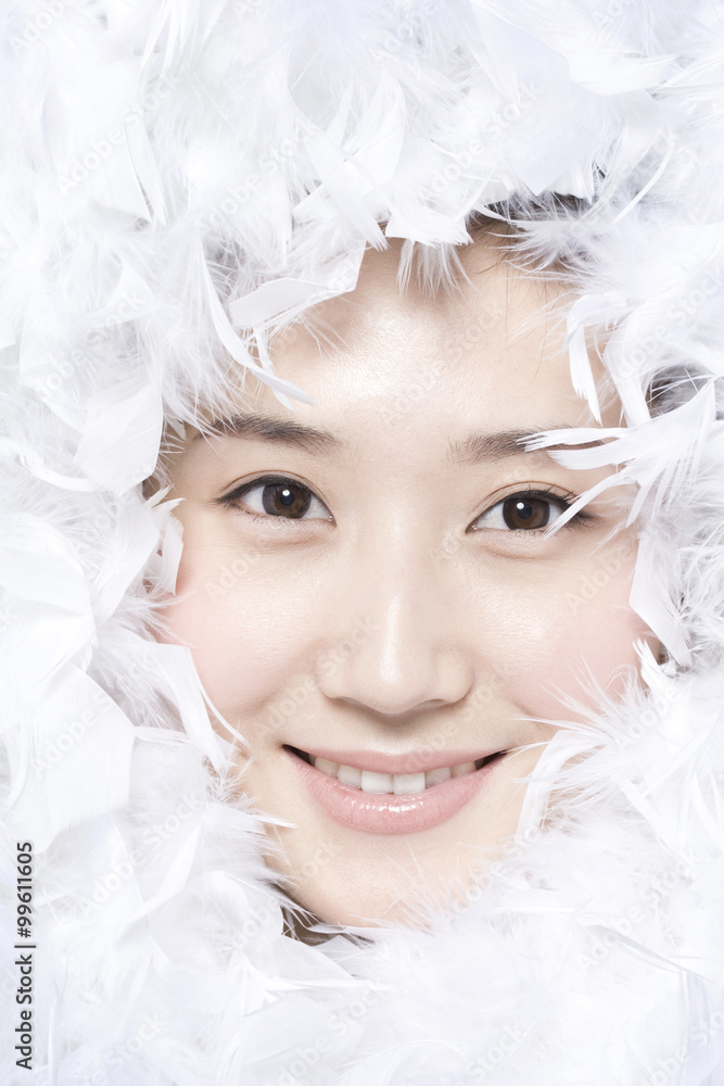 Feathers surrounding the face of young woman