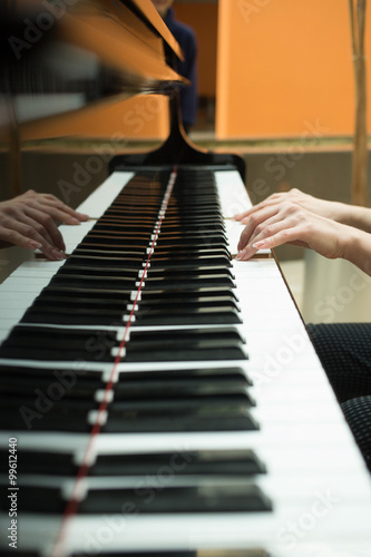 Konstfotografi Women's hands on the keyboard of piano. girl plays music