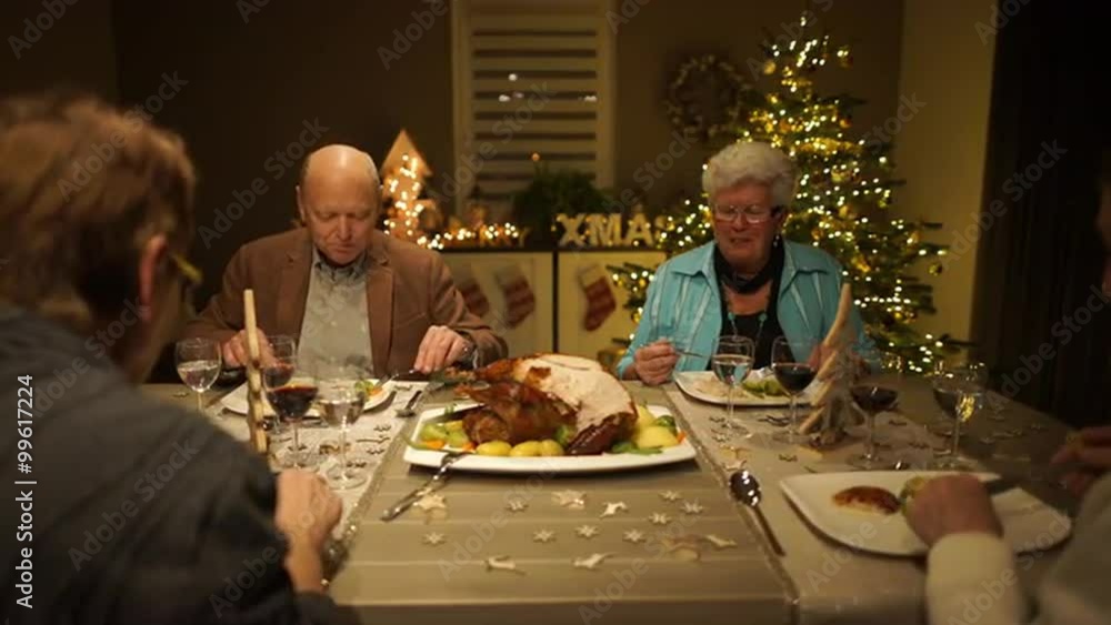 4k footage, dolly move four seniors enjoying roasted turkey on christmas eve in living room, captured with atomos shogun
