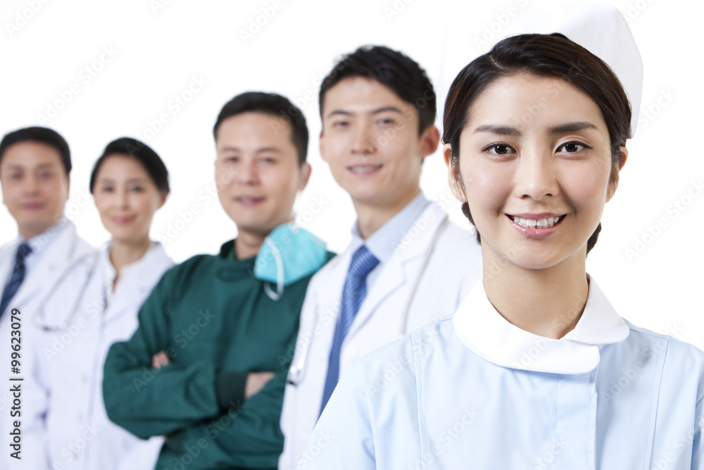Portrait of happy nurse with medical team in background