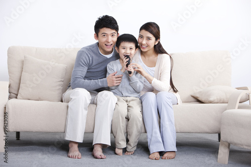 merry young family singing with a microphone at home