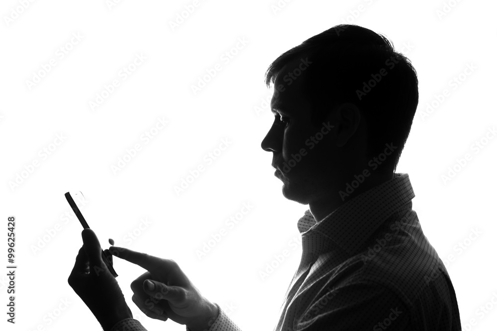 Portrait of a young man with a smartphone, tablet in hand - silhouette