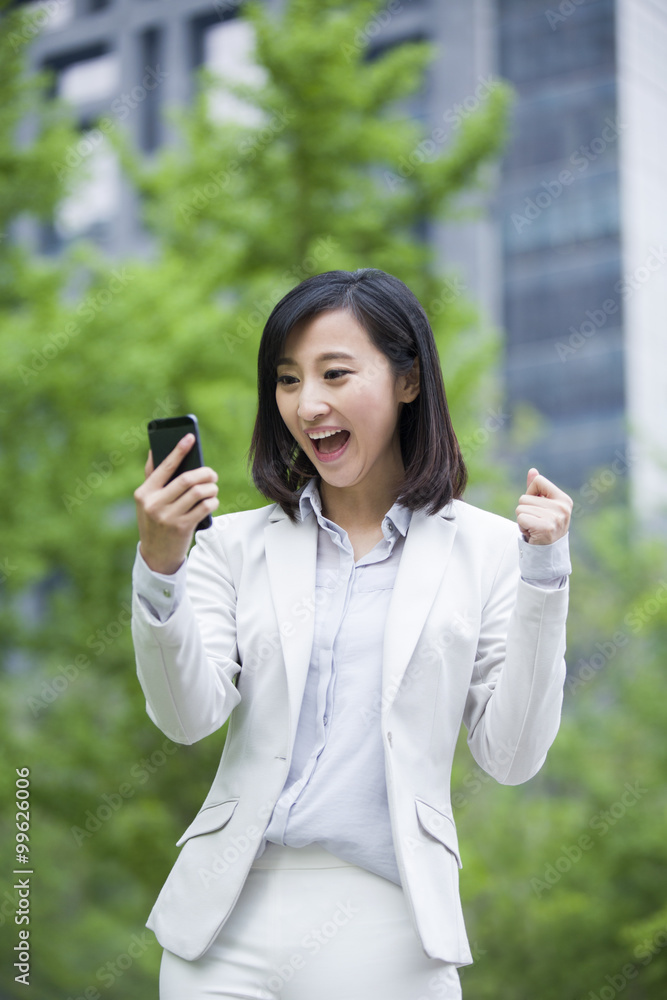 Excited young businesswoman with mobile phone Excited young businesswoman with mobile phone