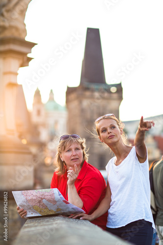 Photography Mother and daughter traveling - two tourists studying a map
