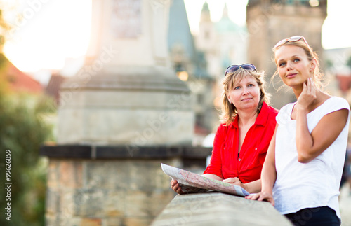 Photography Mother and daughter traveling - two tourists studying a map