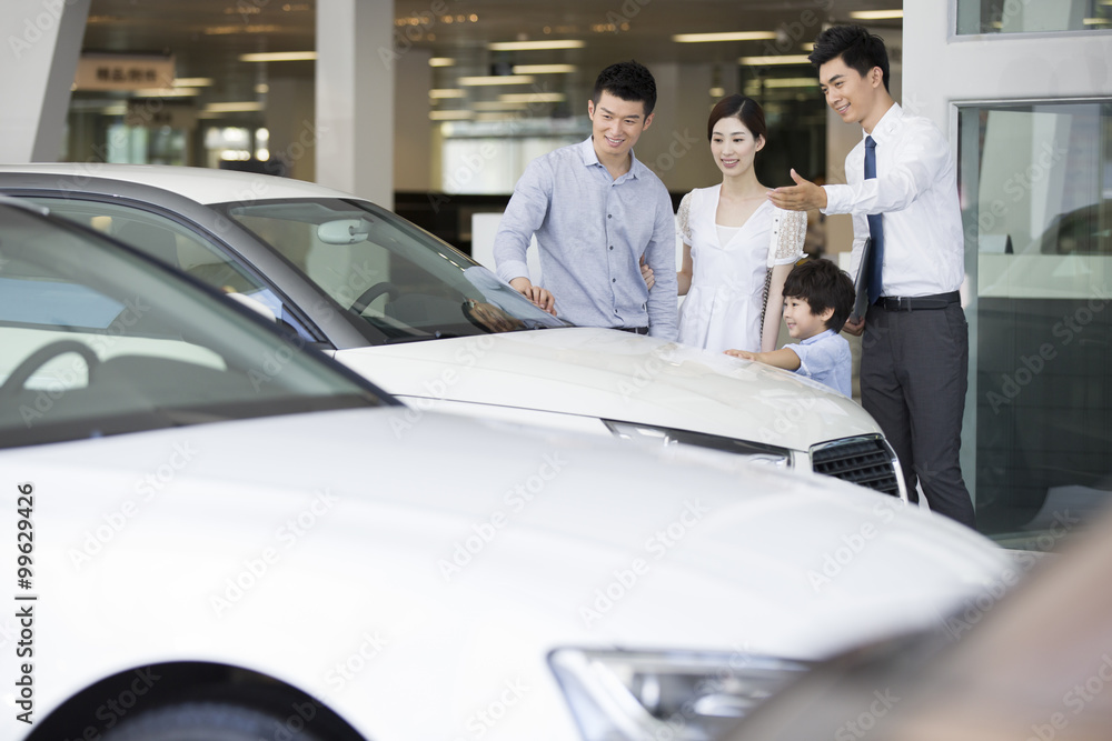 Young family choosing car in showroom Young family choosing car in showroom