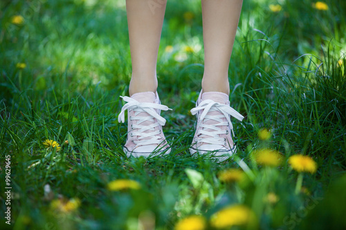 Female legs in shoes on the grass