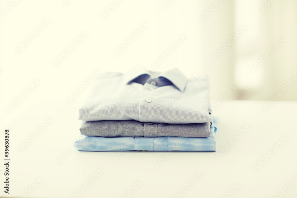 close up of ironed and folded shirts on table close up of ironed and folded shirts on table