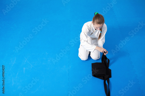 An aikidoka girl folding her hakama for Aikido training photo