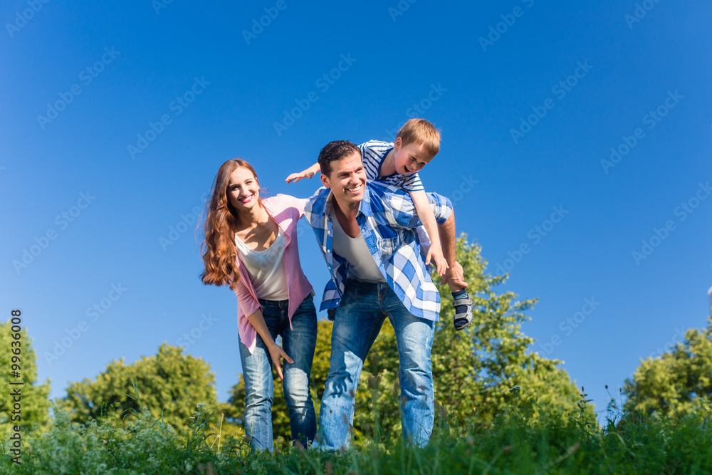 Daddy carrying son piggyback on his back Daddy carrying son piggyback on his back