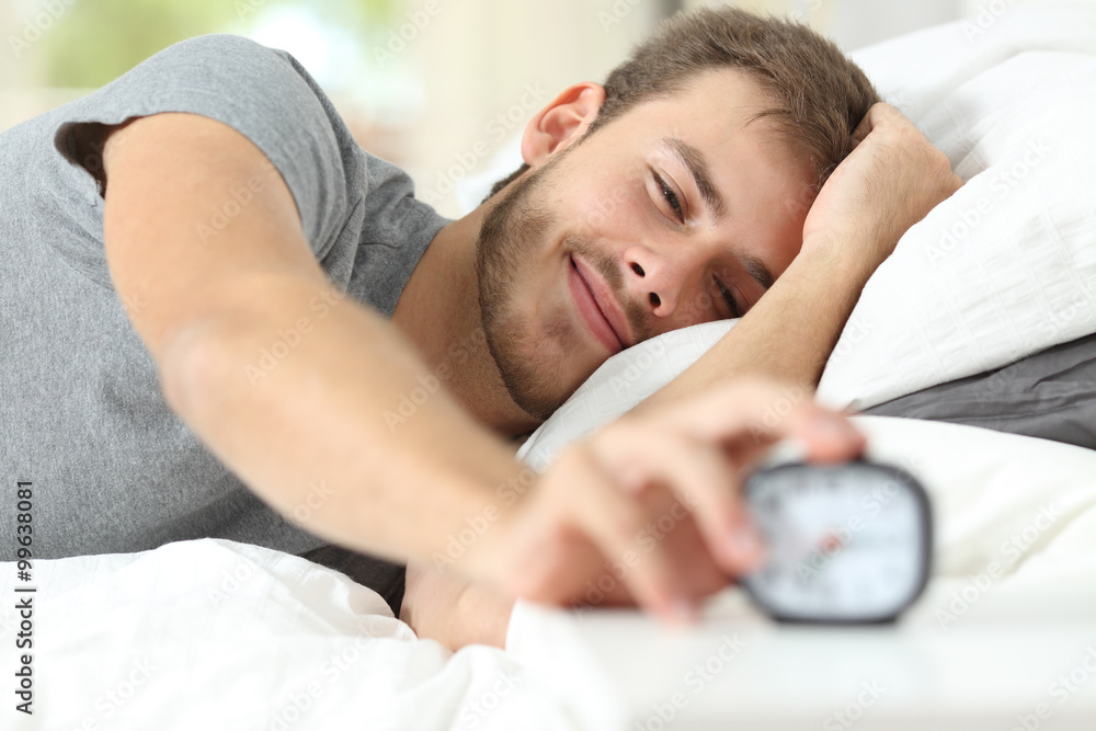 Happy wake up of a happy man stopping alarm clock - obrazy, fototapety, plakaty 