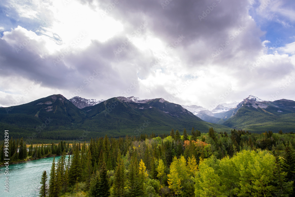 turquoise water of a tranquil river in the middle of the forests and peaks of the rocky mountains of alberta canada