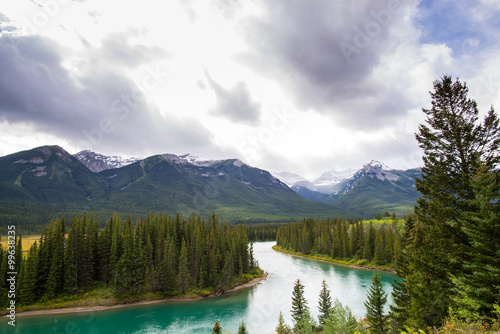 turquoise water of a tranquil river in the middle of the forests and peaks of the rocky mountains of alberta canada