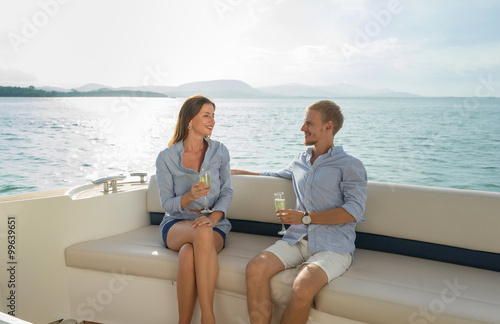 Romantic vacation .Luxury life. Beautiful couple drinking sparkling wine on the board of yacht