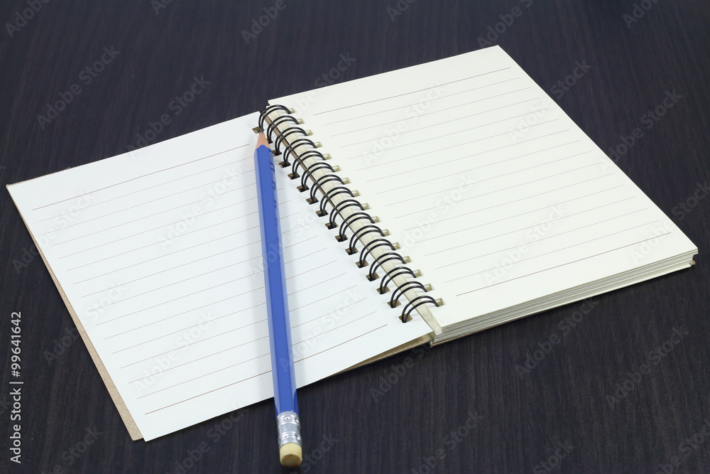 notebook, Pebble Beach and blue pencil on wooden table. notebook, Pebble Beach and blue pencil on wooden table.
