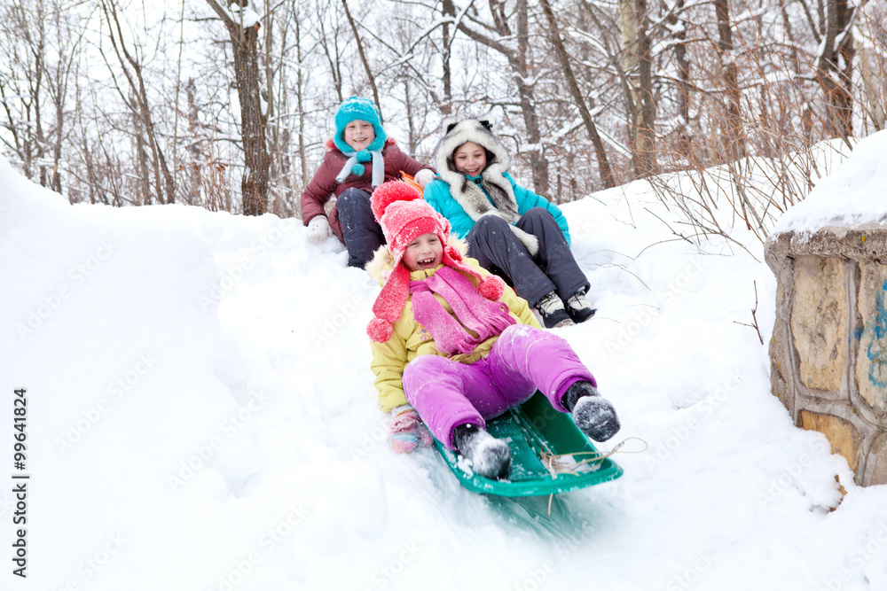 Cheerful happy children sledding winter day