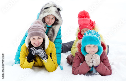 Happy cheerful family lying in the snow on a winter outing