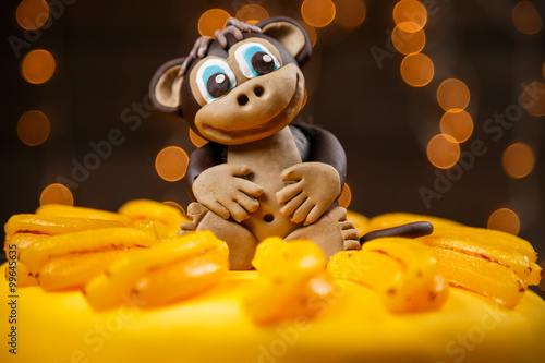 Cake witn funny monkey among marmalad bananas on the top for the Chinese New Year 2016 photo