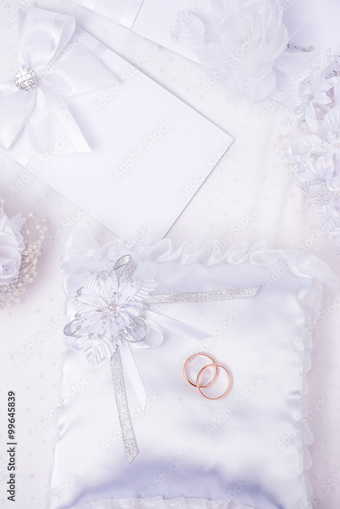 The wedding invitation with wedding rings and a bouquet of the bride on a white background The wedding invitation with wedding rings and a bouquet of the bride on a white background