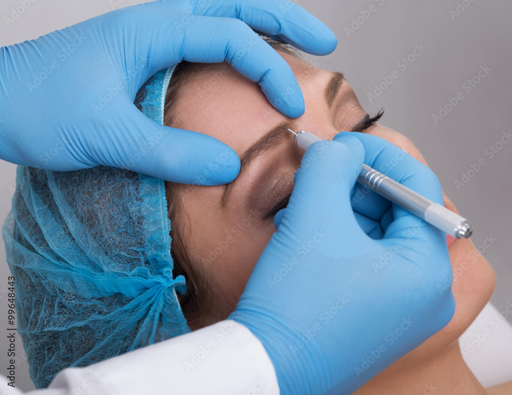 Young woman getting a permanent eyebrow make up treatment Young woman getting a permanent eyebrow make up treatment
