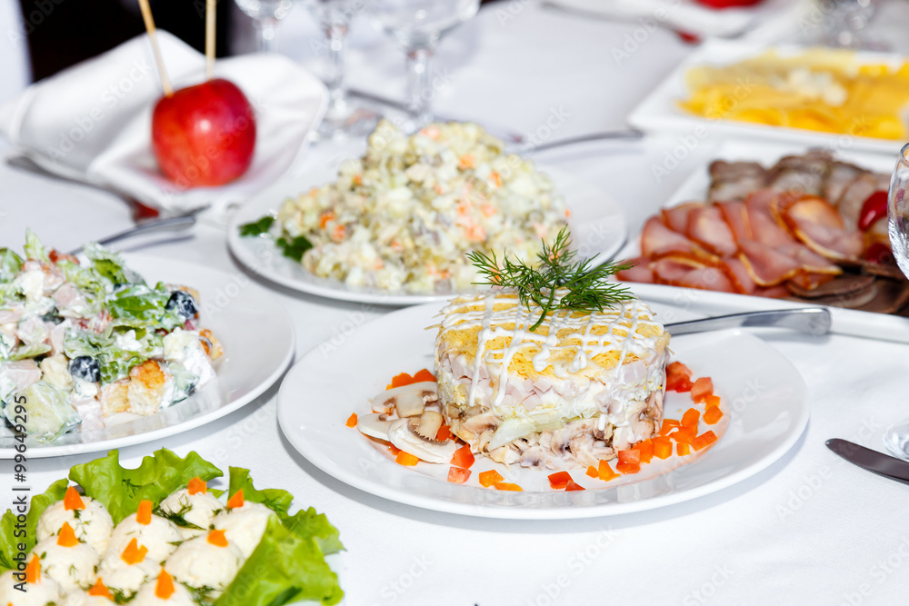 Cutting sausages and salads on a banquet table Cutting sausages and salads on a banquet table