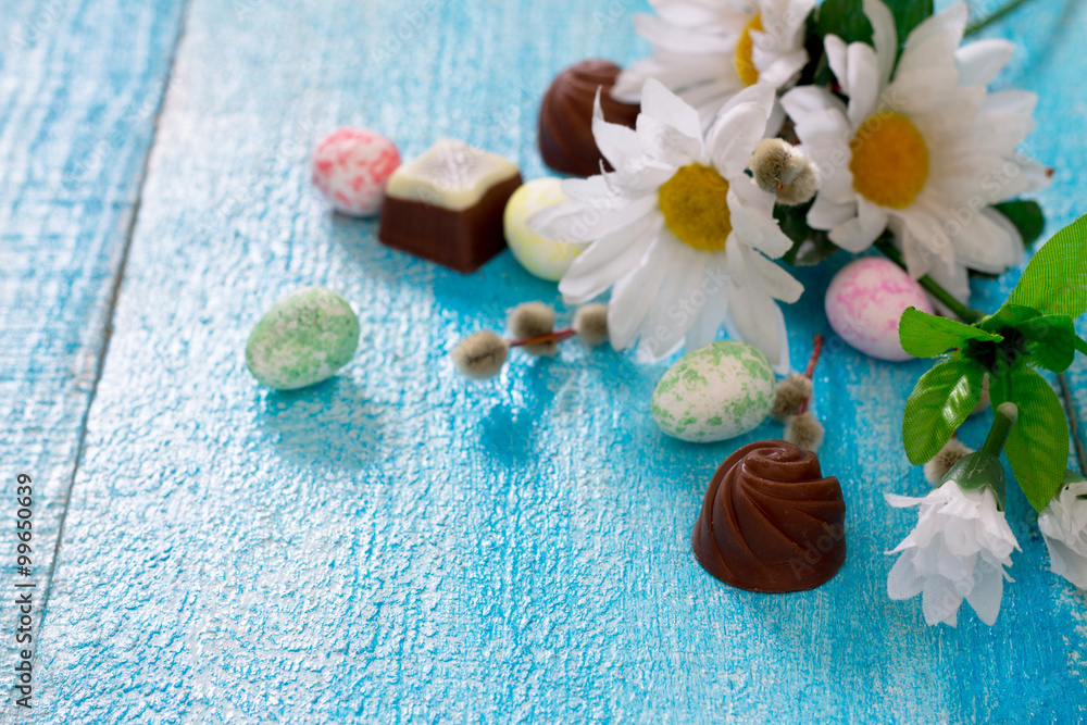 Colorful Easter eggs, spring flowers and chocolates Colorful Easter eggs, spring flowers and chocolates