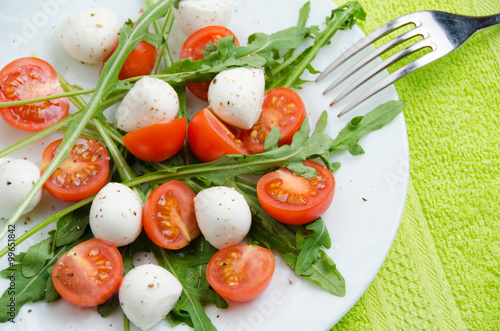 Vegetable salad of arugula, cherry tomatoes and mozzarella