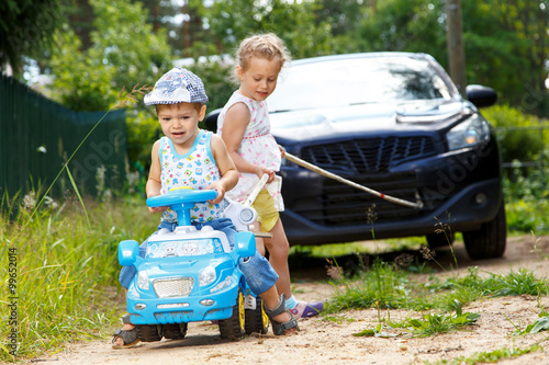 Photos Two kids try to tow real automobile with the help of toy car