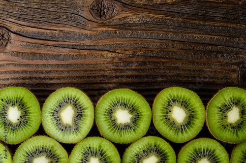 Frame of kiwi fruits on wooden background