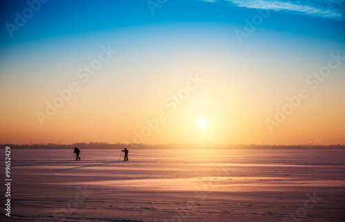 Beautiful winter sunset landscape with cross-country skiers