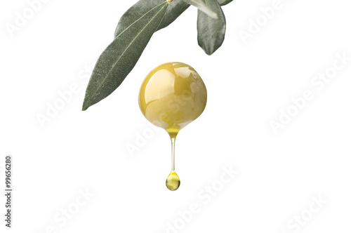 A drop of olive oil falling from one green olive on a white